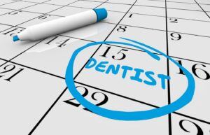 Whiteboard calendar with dentist appointment on it