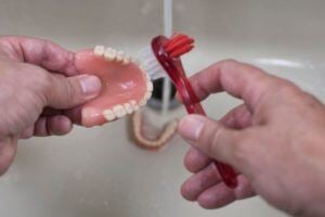 Person cleaning dentures