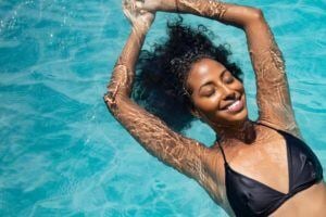 Smiling woman floating in swimming pool