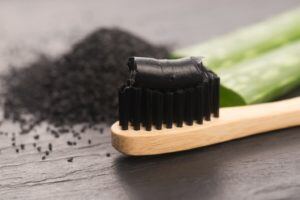 Toothbrush with charcoal toothpaste on it